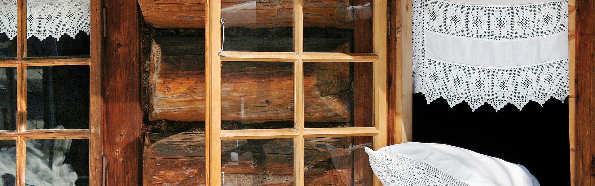 Eine historische Holzkirche mit geöffnetem Fenster und Holzstickereien