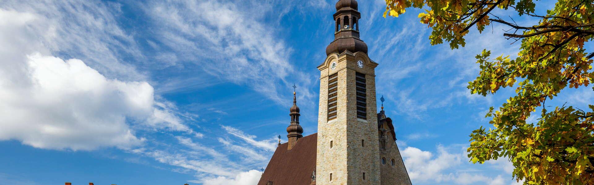 Der Stadtplatz mit einem hoch aufragenden steinernen Kirchturm im Hintergrund